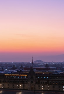 A panoramic shot of the Iraqi parliament building at sunset with warm red hues.