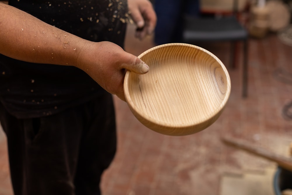 a person holding a wooden bowl