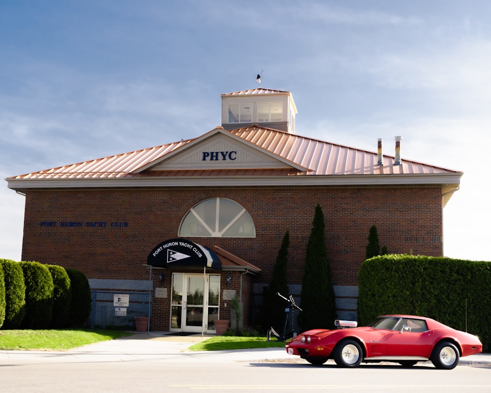 a red car parked outside a building