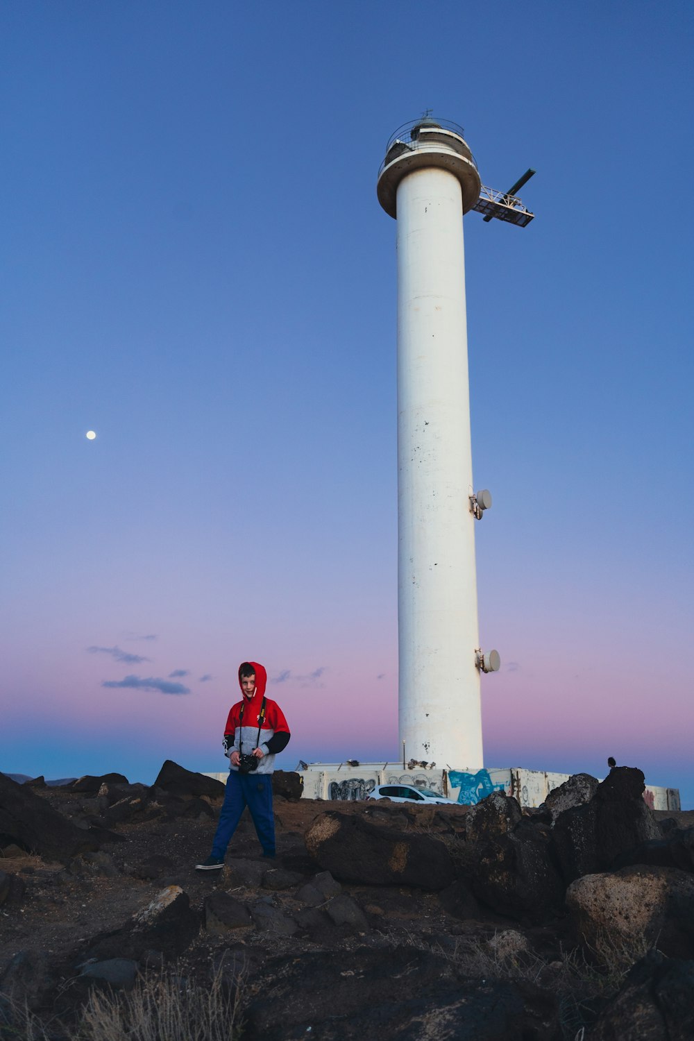a man standing next to a lighthouse