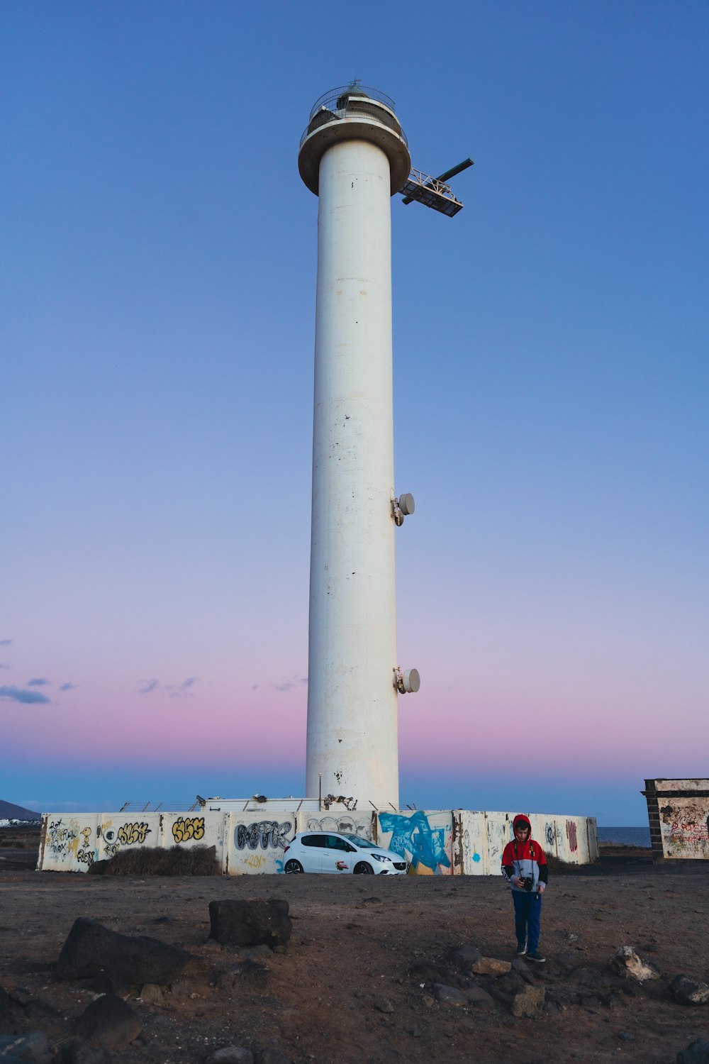 a person standing next to a tall tower