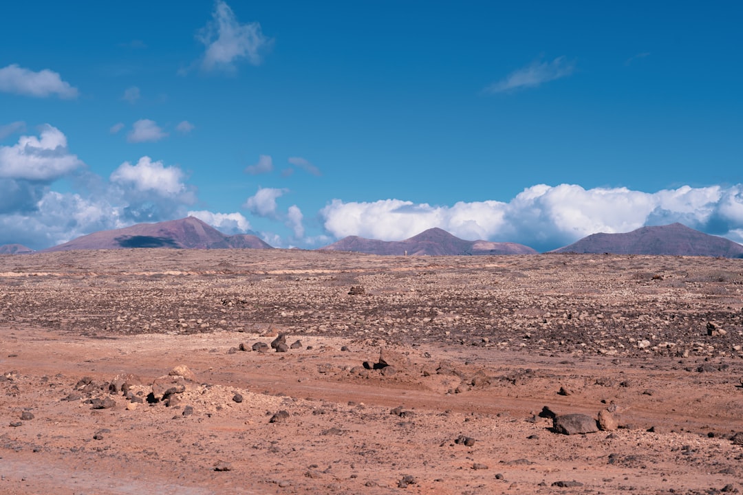 a desert landscape with mountains in the background,