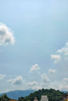 A serene temple view at Kedarnath surrounded by lush greenery and clouds