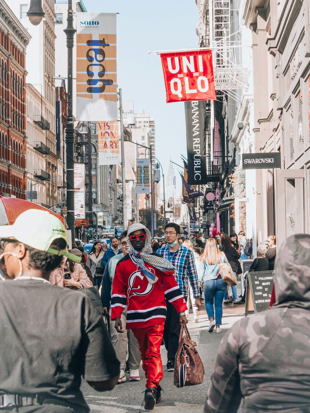 a person in a garment walking down a busy street