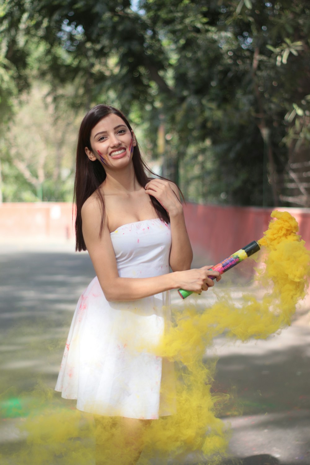 Una mujer con un vestido blanco sosteniendo una flor amarilla