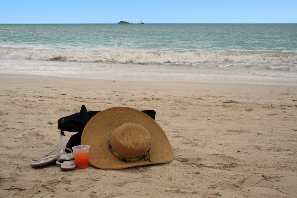 a hat and sunglasses on a beach