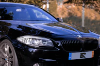 A stylish black car fitted with silver and red premium wheels parked outdoors.