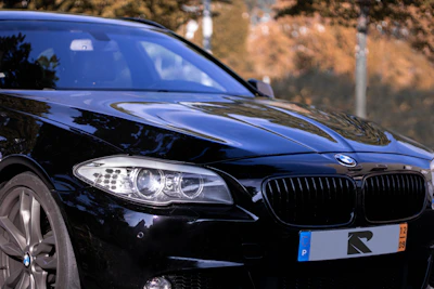 A stylish black car fitted with silver and red premium wheels parked outdoors.
