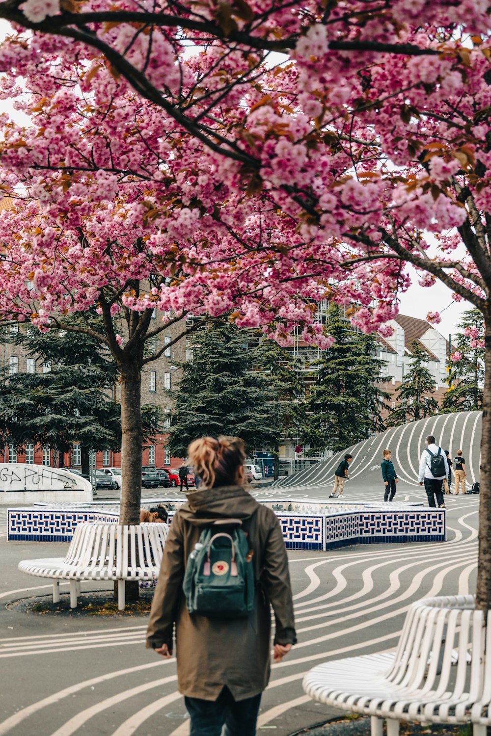 a person walking on a street with trees on either side of it