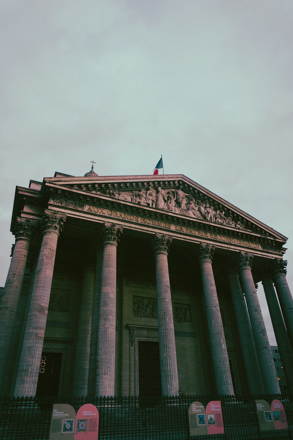 a building with pillars and a fence