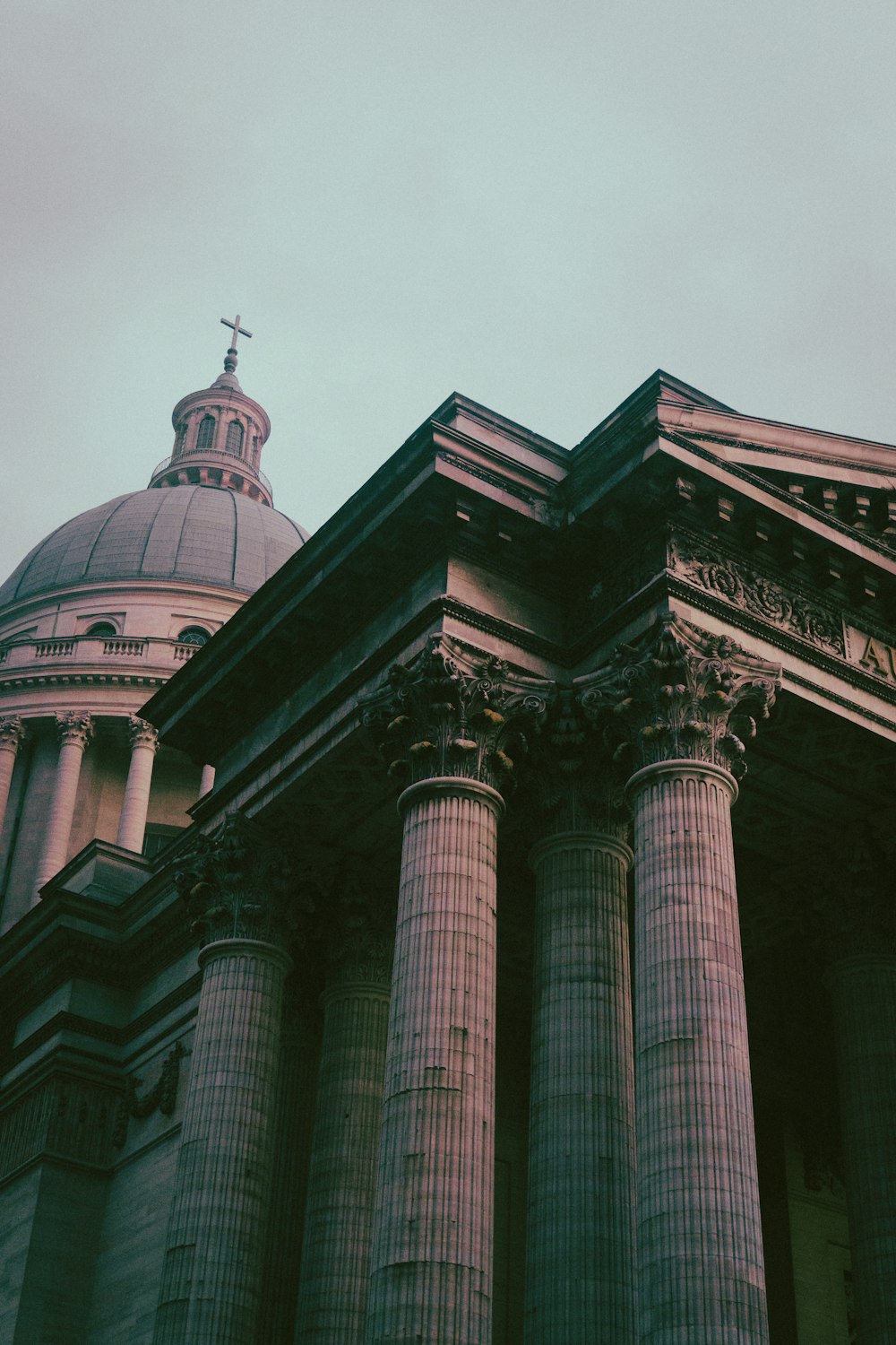 a building with pillars and a cross on top