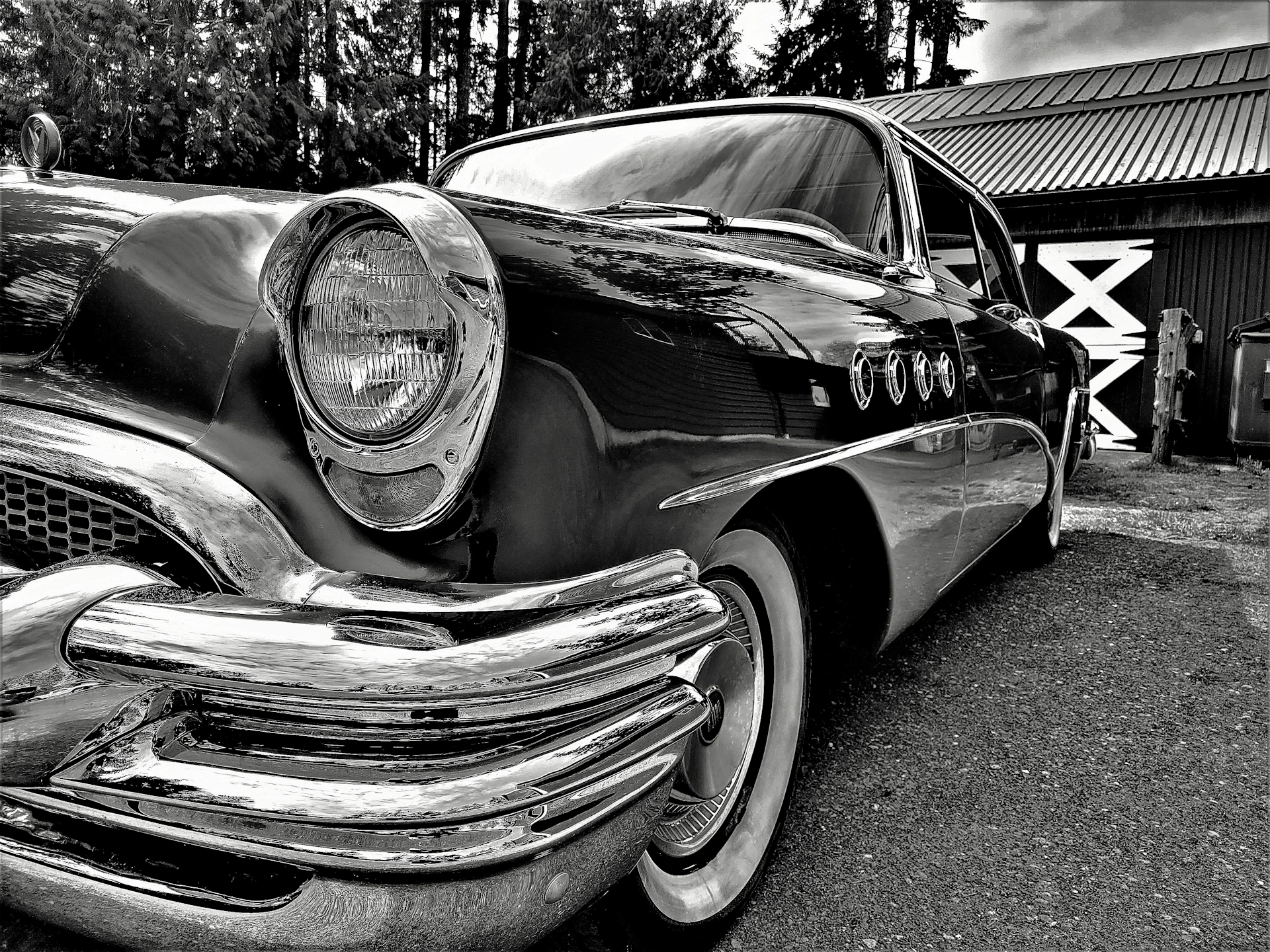 A classic vintage car parked beside a rustic barn, showcasing timeless design.