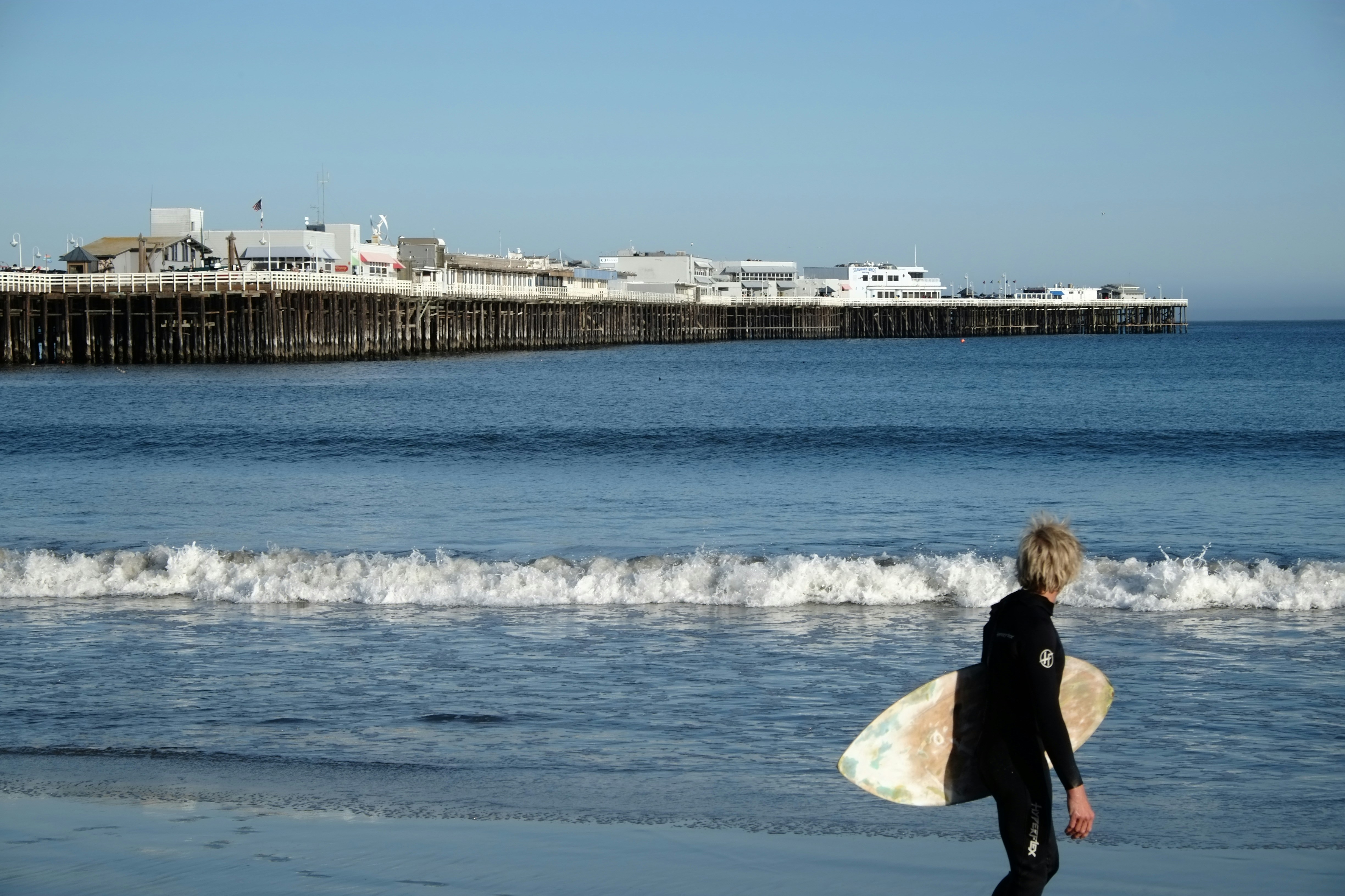 a person carrying a surfboard on a beach