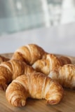 A selection of flaky croissants arranged on a plate.