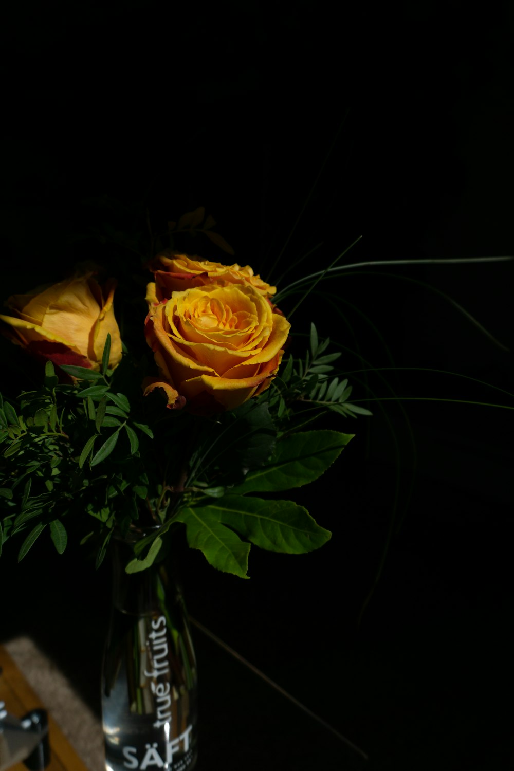 a vase with yellow roses