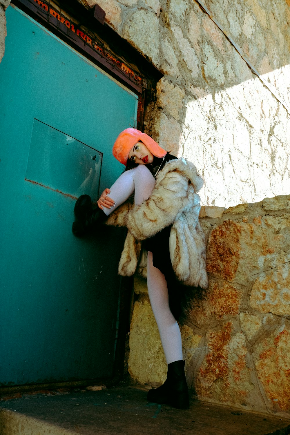 a person in a garment leaning against a wall