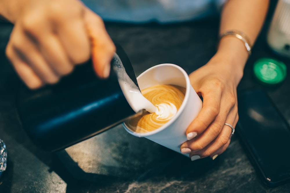 a person pouring a liquid into a cup