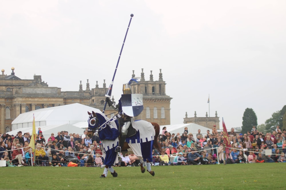 a person in a garment holding a sword in front of a crowd