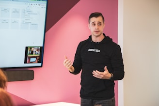 a person standing in front of a screen with the hands out
