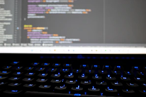 Close-up of a programmer coding AI software on a laptop with blockchain graphics.