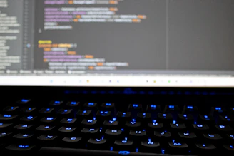 Close-up of hands typing on a keyboard with code and security icons overlay.