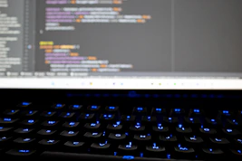 Close-up of a student coding a game environment on a computer screen filled with colorful graphics.