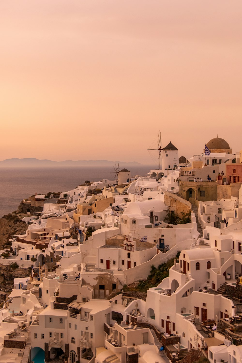 a city with white buildings and a body of water in the background