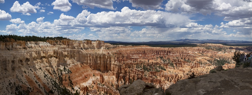 a large canyon with a few people standing on the side