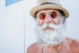 a man with a white beard and mustache wearing a hat