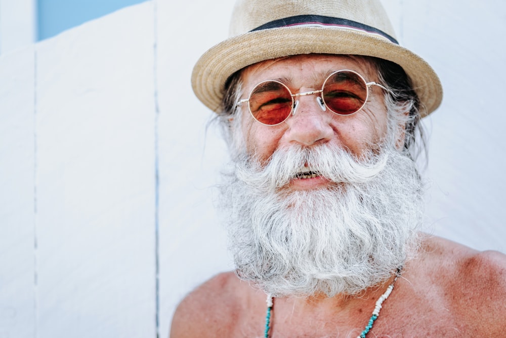 a man with a white beard and mustache wearing a hat