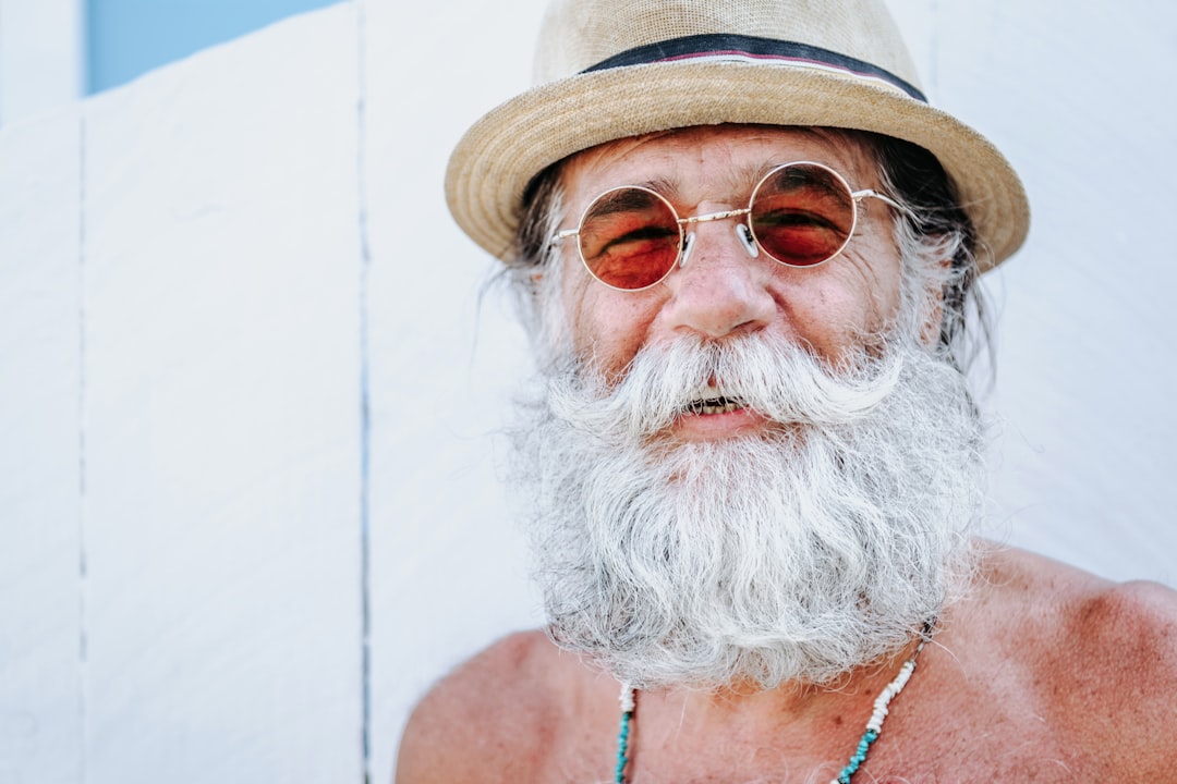 a man with a white beard and mustache wearing a hat, Retired and happy