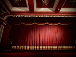 Elegant stage set for Cavalleria Rusticana performance with rich red velvet curtains