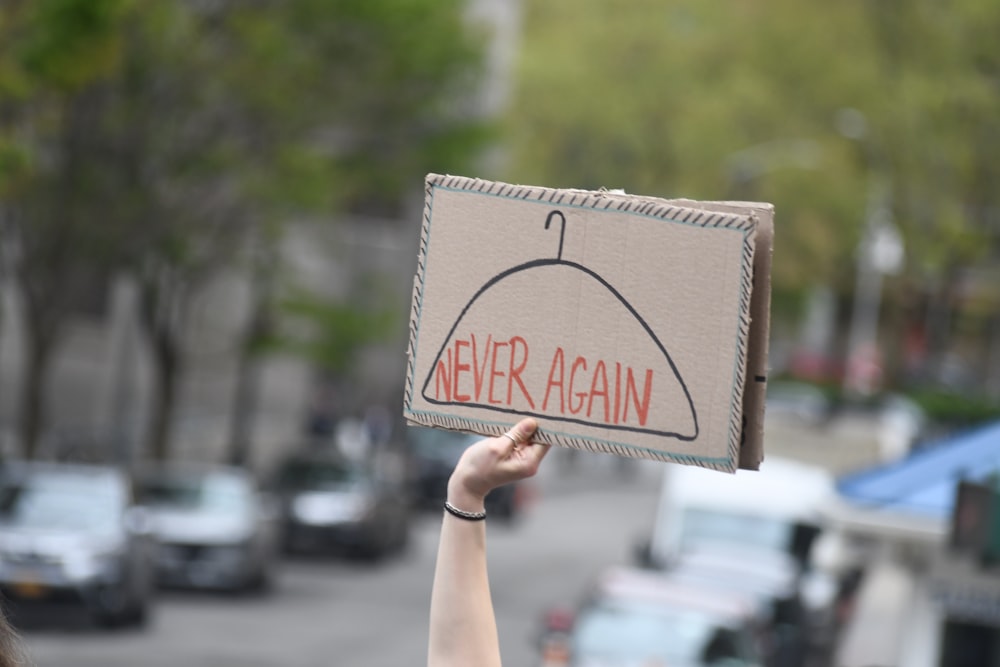 a hand holding a sign