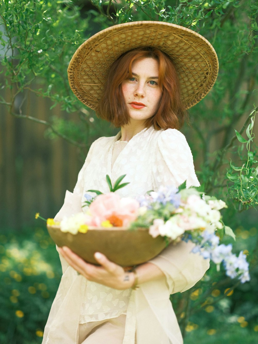a woman holding a bowl of flowers