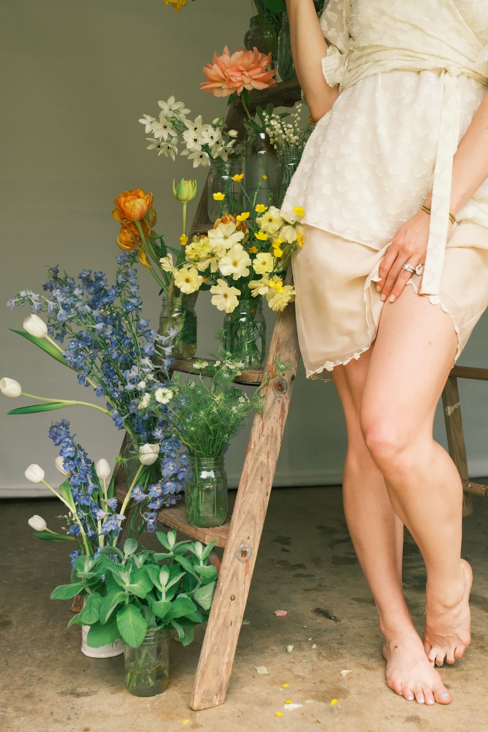 a woman standing next to a vase of flowers