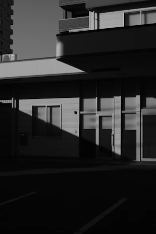 Minimalist exterior facade of a building emphasizing contrast between light and shadow.