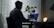 A close-up of a person using headphones while working on a laptop in a dimly lit room.