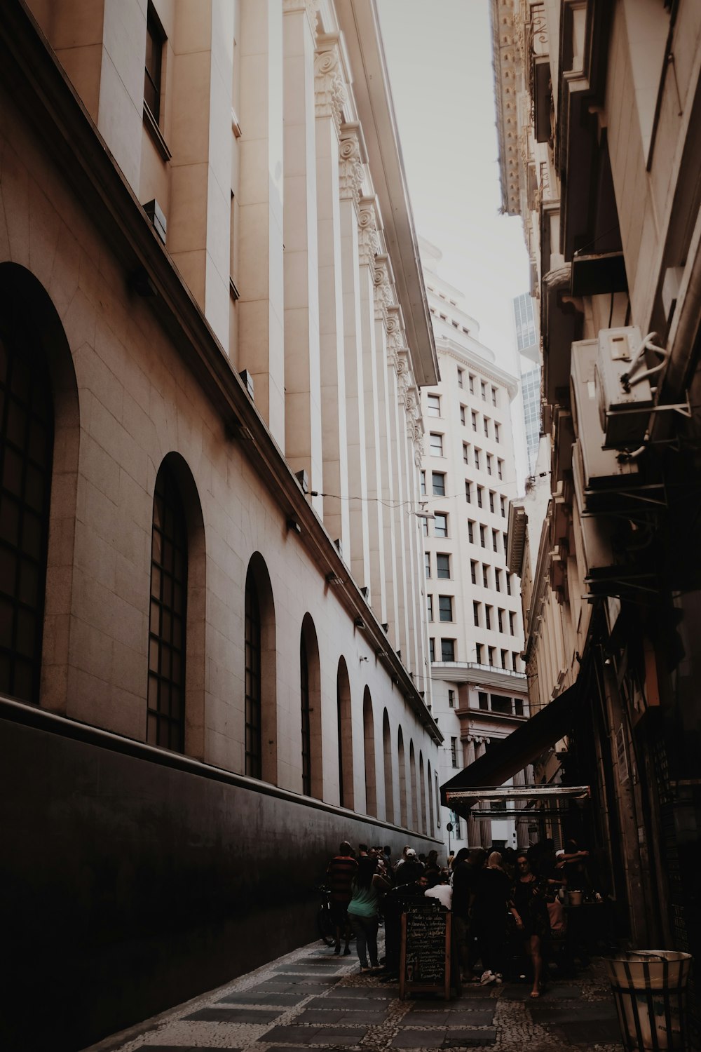 a group of people standing in a street between buildings