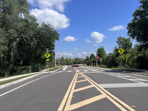 A calm city intersection showing clear road signs and a beginner driver waiting patiently.