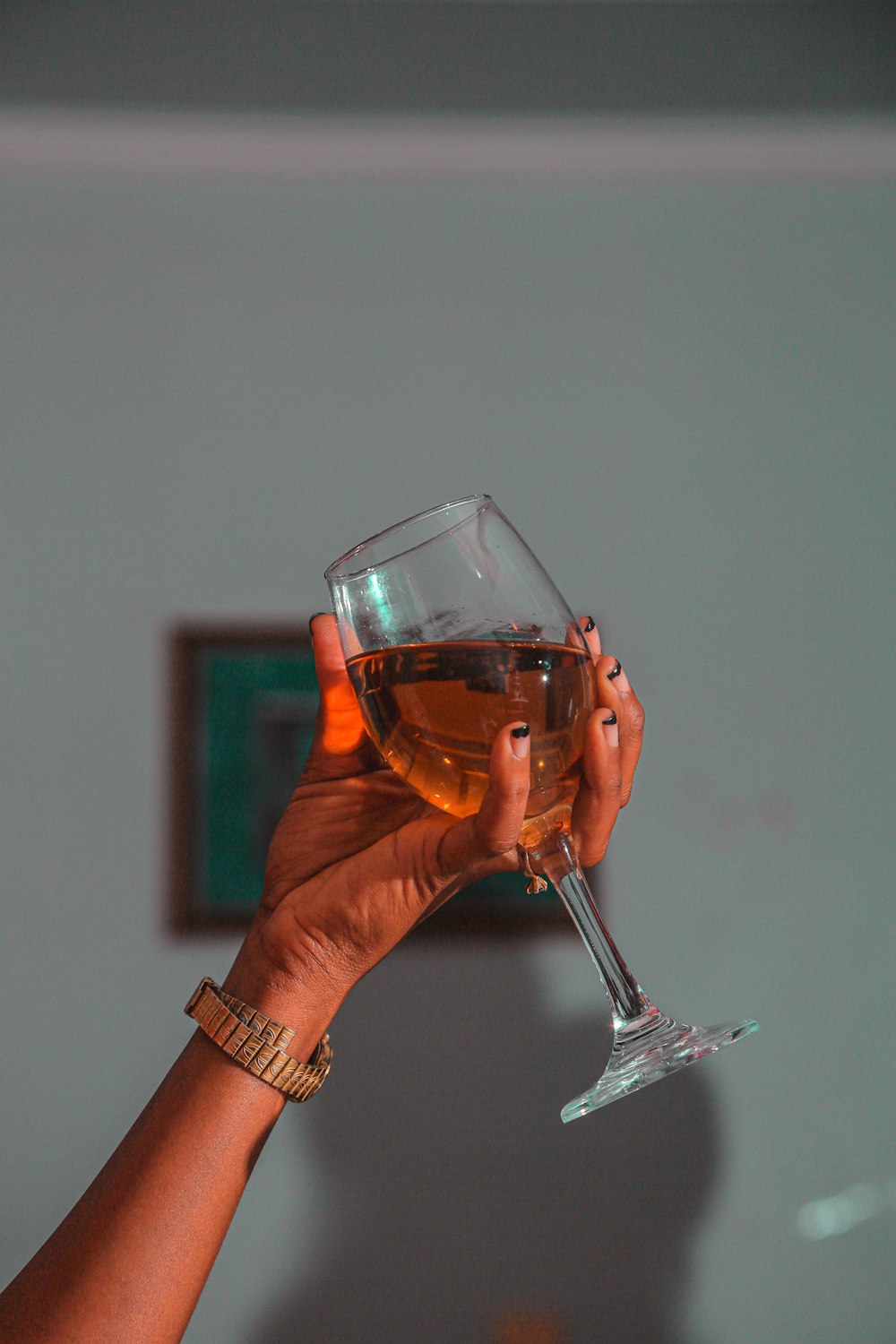 a hand holding a glass of wine