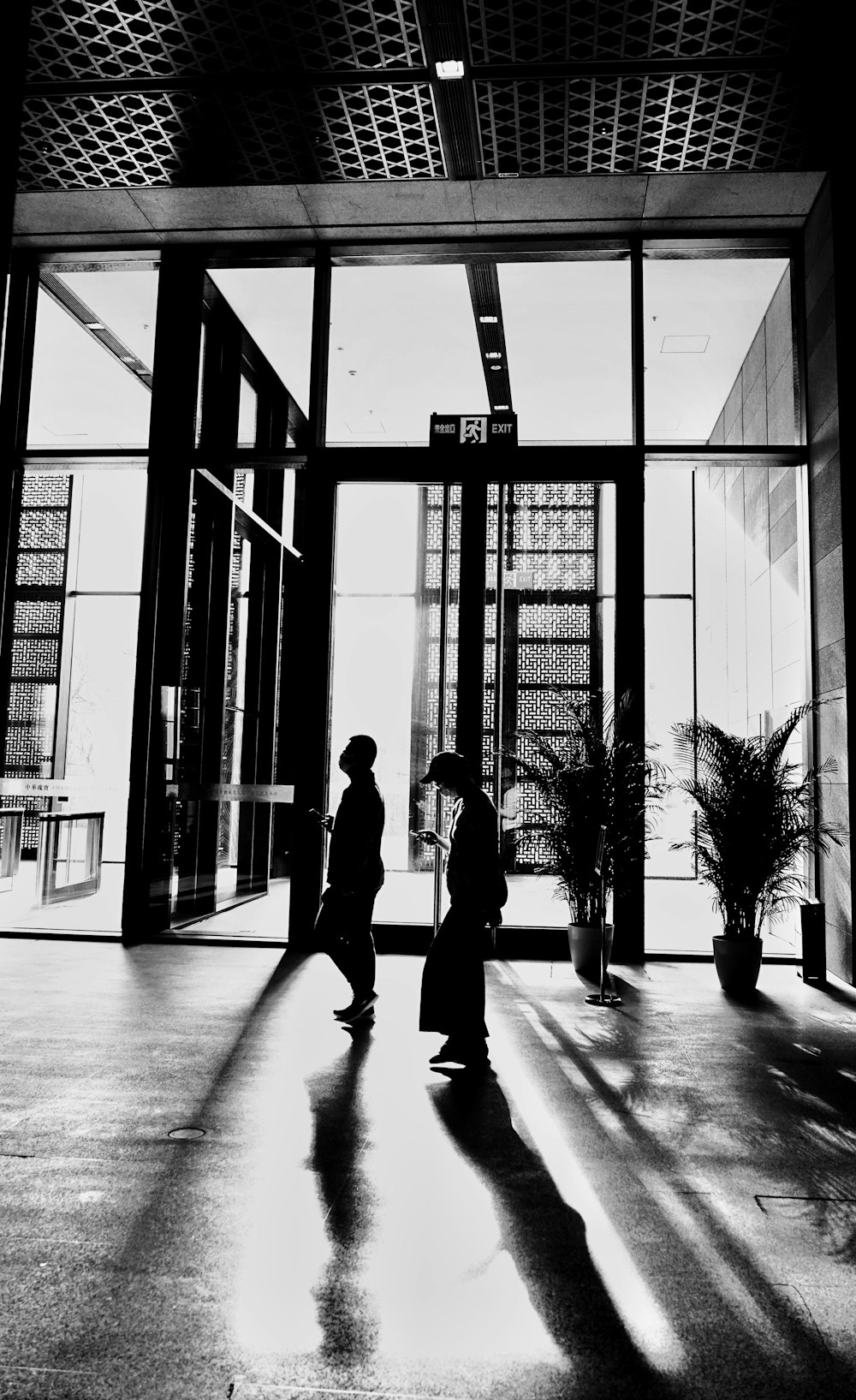 a couple of men standing in front of a glass building