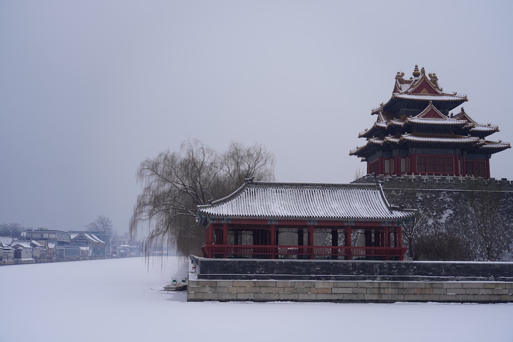 Un edificio con un techo rojo y un suelo cubierto de nieve