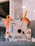 A machine with the brand name 'Jackarmy' is visible. It has a white and silver body with a lever that has a yellow and black handle. There is an orange component attached to the machine, possibly a spool or wheel. Nearby, there are some photo stickers attached to the machine.