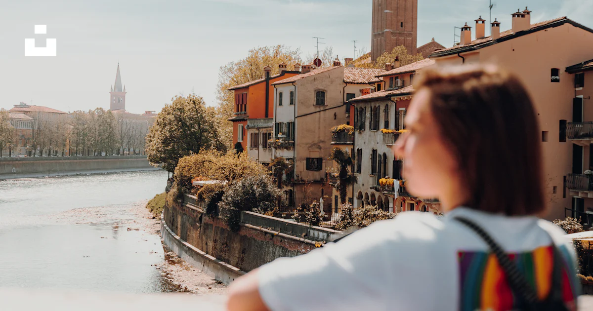 Italy Ledges A person sitting on a ledge looking at a clock tower photo – Free Italy ...