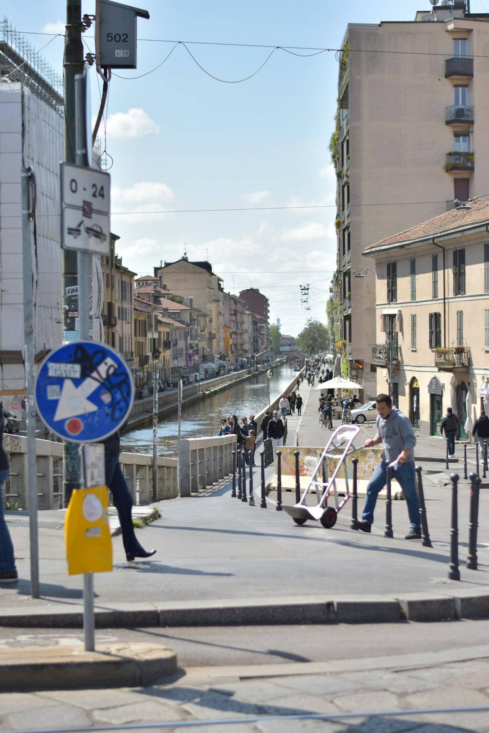 a street with a sign and people walking on it