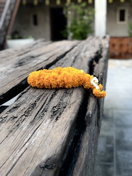 Close-up of marigold garlands draped over a rustic wooden crate.