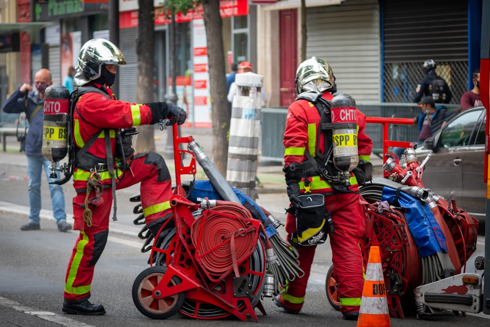 Una coppia di uomini in abiti rossi che spingono una motocicletta