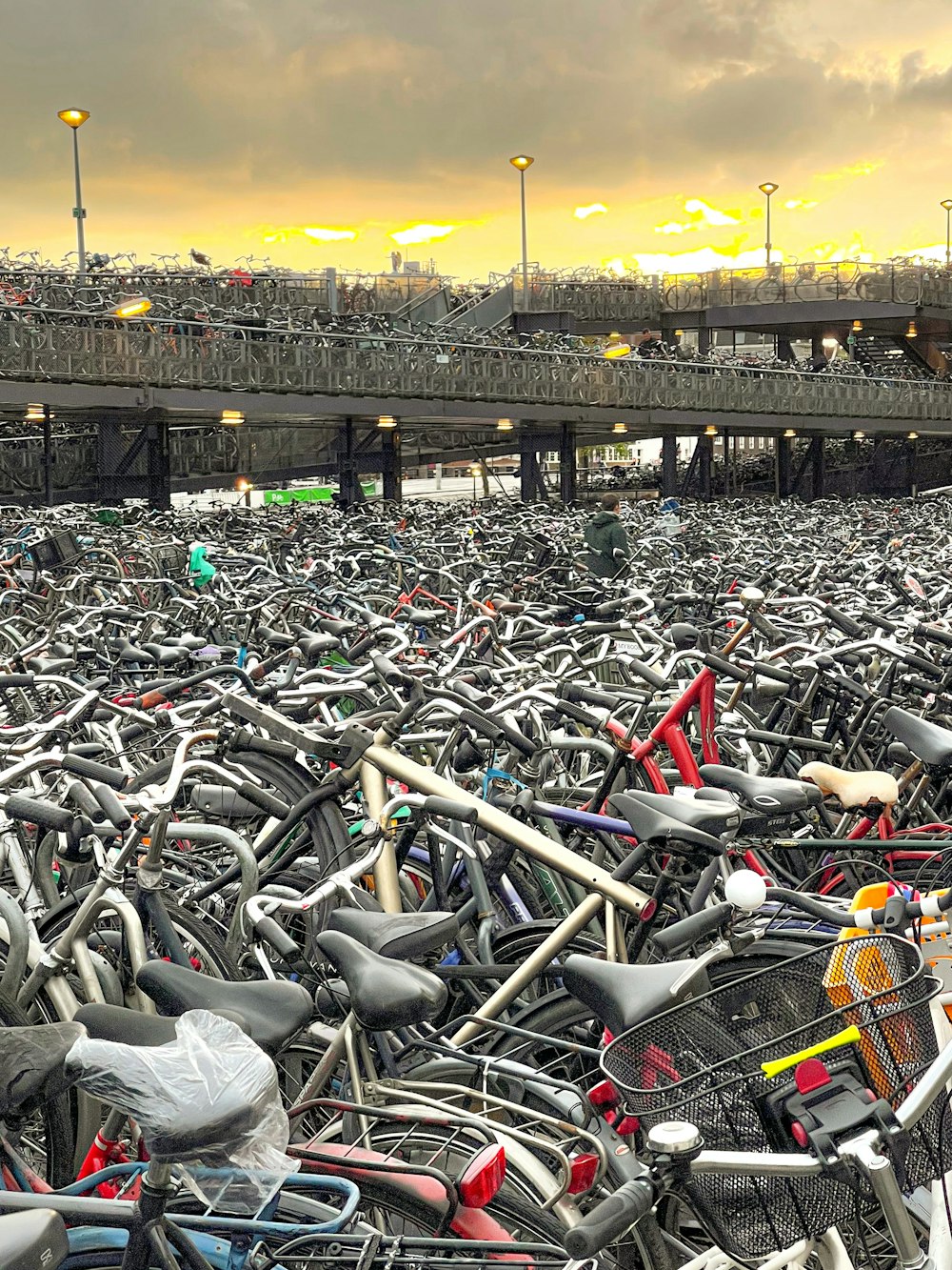 a large group of bicycles parked in front of a bridge