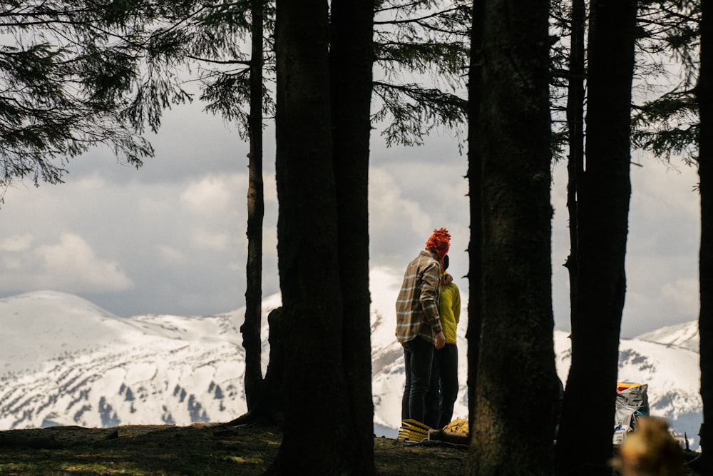 a couple of people standing in a forest