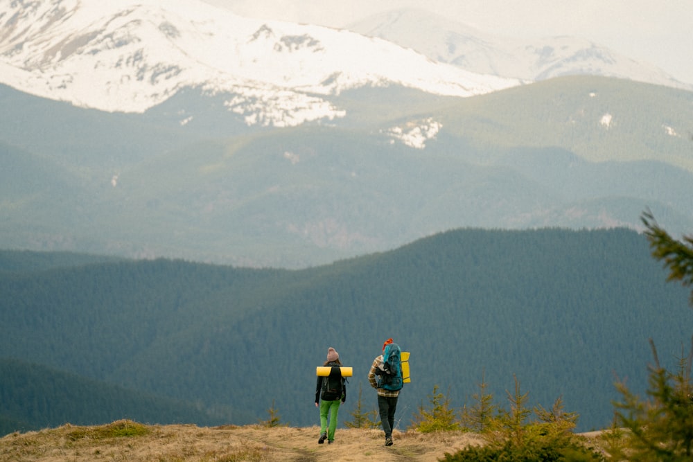 two people walking on a mountain